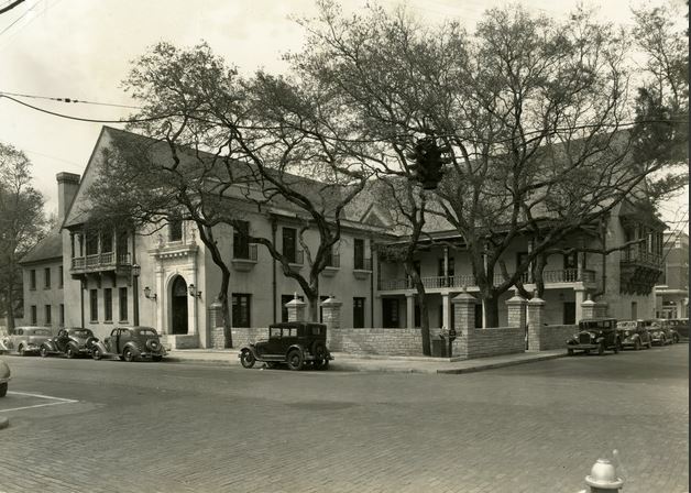 A black and white photograph of Government House from 1930s with cars lining the street.
